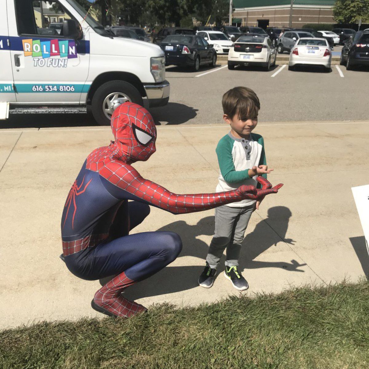 a boy sitting in a parking lot