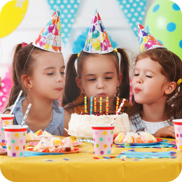 a little girl sitting in front of a birthday cake