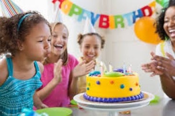 a woman standing in front of a birthday cake