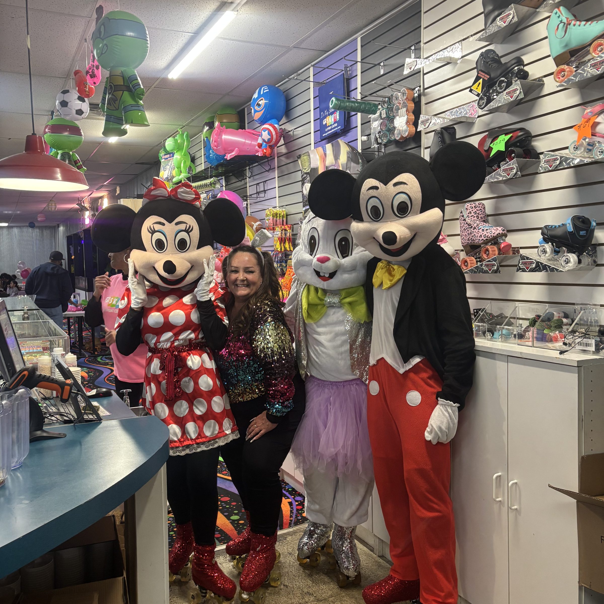 Three people in Mickey Mouse costumes posing in a store.