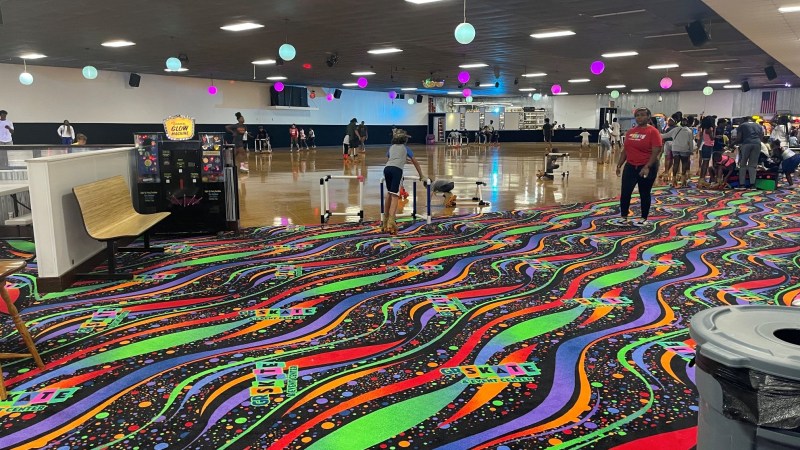 Colorful roller skating rink with a vibrant carpet and skaters.